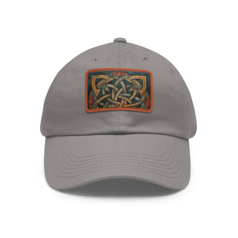 Celtic knot design white cotton baseball cap with light brown patch.