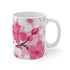 Pink and white cherry blossom ceramic coffee mug with seamless nature pattern.