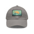 Minimalist white baseball cap with light brown patch showcasing mountain landscape.